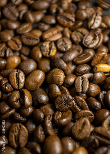 Dark background and texture of coffee beans, selective focus, closeup grains.