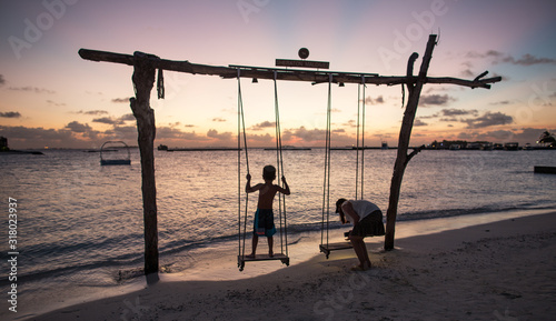 wooden swing on the beach at sunset