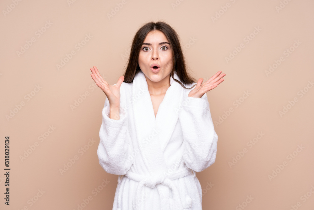 Young girl in a bathrobe over isolated background with surprise facial expression Young girl in a bathrobe over isolated background with surprise facial expression