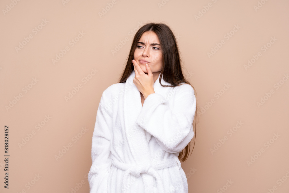 Young girl in a bathrobe over isolated background thinking an idea Young girl in a bathrobe over isolated background thinking an idea