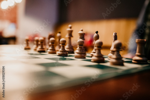 Chess figures on wooden background. Wooden chess pieces including king, queen, pawn, knight and rook 