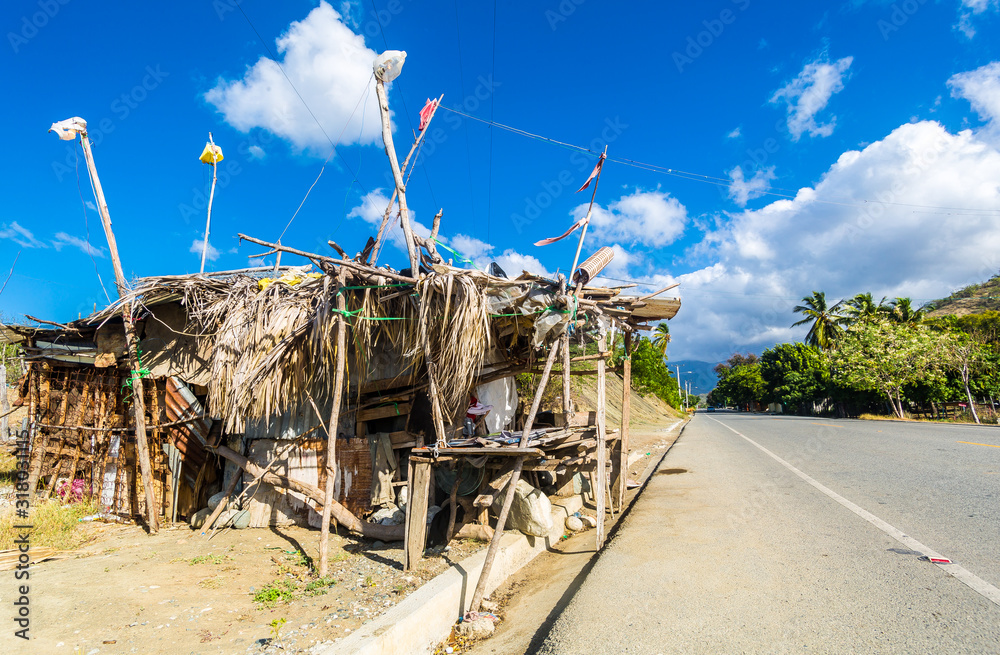 dramatic image of a street vender in a shack selling fruit and vegtables in the dominican republic. dramatic image of a street vender in a shack selling fruit and vegtables in the dominican republic.