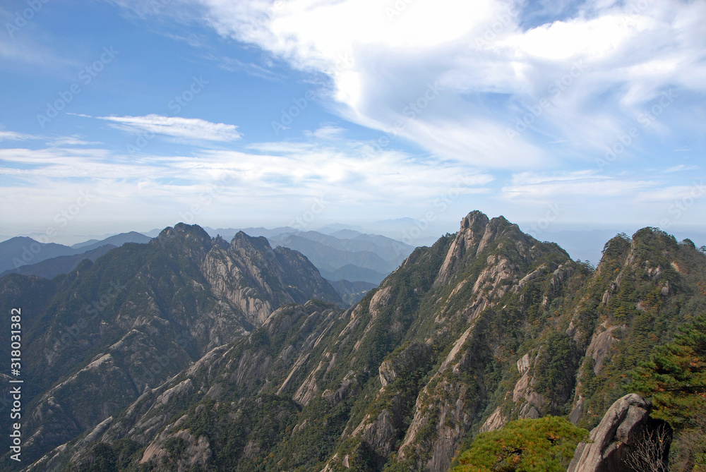 Huangshan Mountain in Anhui Province, China. View of Tmountain peaks and distant hills on the path to Lotus Peak, the highest point of Huangshan. Scenic view of peaks on Huangshan Mountain, China.