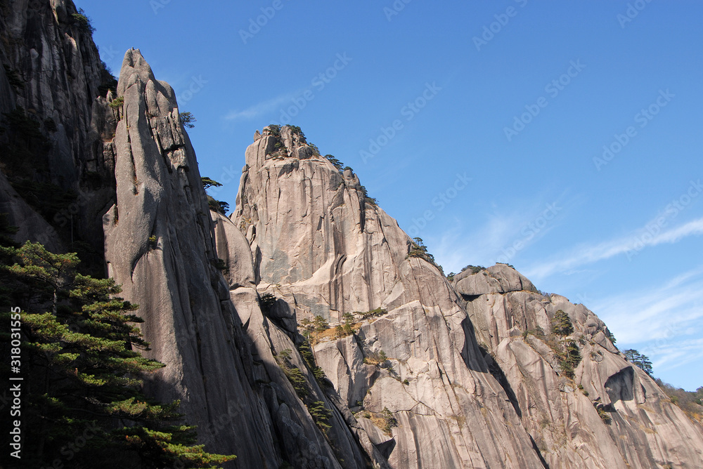 Huangshan Mountain in Anhui Province, China. Rocky cliffs and pine trees below the summit of Lotus Peak, the highest point of Huangshan. Scenic view on Huangshan Mountain, China. Huangshan Mountain in Anhui Province, China. Rocky cliffs and pine trees below the summit of Lotus Peak, the highest point of Huangshan. Scenic view on Huangshan Mountain, China.