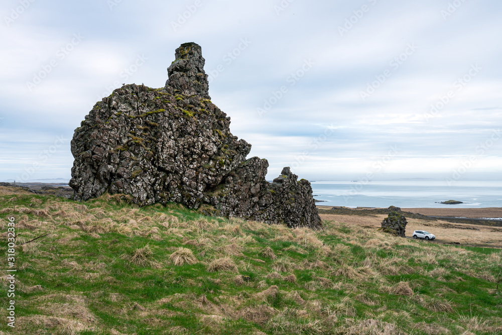 Φωτογραφία Basalt sculpture volcanic rock in the eastern part of Iceland with white car and the atlantic ocean in the background