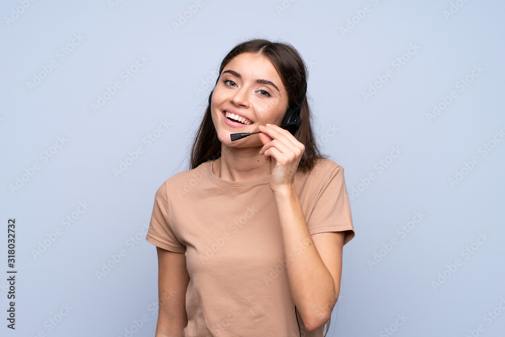 Young woman over isolated blue background working with headset Young woman over isolated blue background working with headset