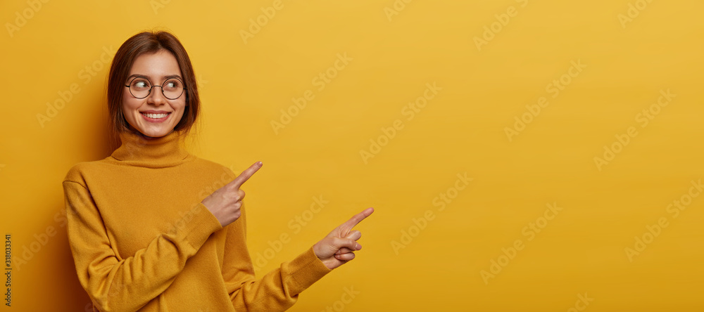 Φωτογραφία Studio shot of pleasant looking young woman with dark combed hair, wears neck sw