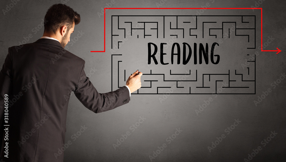 businessman drawing maze with READING inscription, business education concept businessman drawing maze with READING inscription, business education concept
