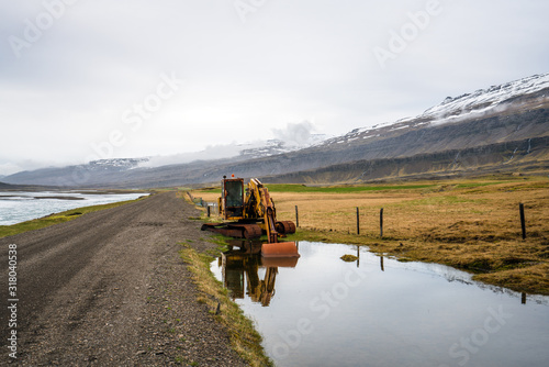 Old and rusty excavator by the side of a gravel road and the river Hamarsa. From Hamarsdalur near Bragdavellir in east Iceland. Travel and landscape concept. photo
