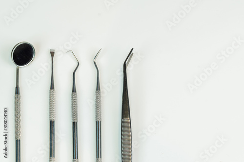 Set of composite filling instruments for dental treatment. Dental mirror  probes  tweezers and mask on blue background. Medical tools. Shallow depth of field. Focus on a mirror. 