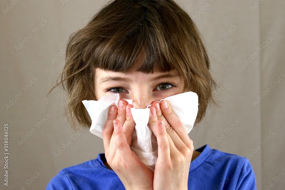 Portrait of a sick child blowing her nose with a tissue - obrazy, fototapety, plakaty 