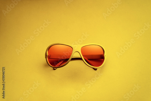 Red sunglasses on electric yellow background