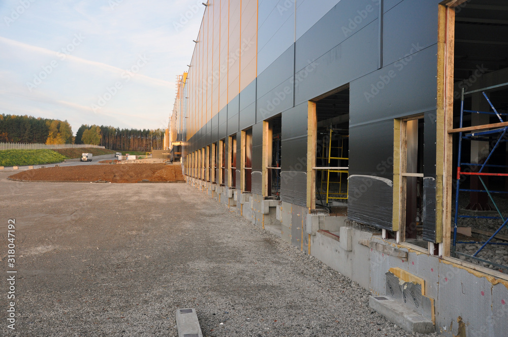 Outdoor photo of the construction of a large industrial and commercial building from technological metal structures.