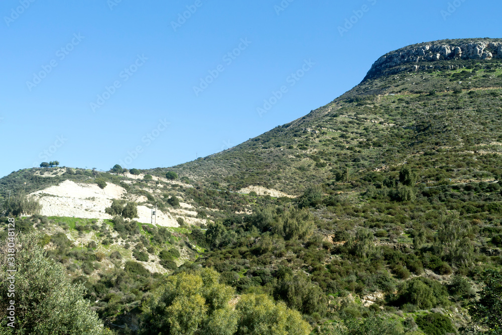 Green mountain slope and blue sky