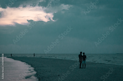 couple walking on the beach at sunset
