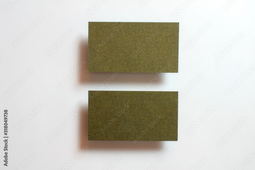 Two Gold blank matt textured business cards flying and isolated on white paper background, us standard size 3.5 x 2 inches, real non professional studio photo. Two Gold blank matt textured business cards flying and isolated on white paper background, us standard size 3.5 x 2 inches, real non professional studio photo.