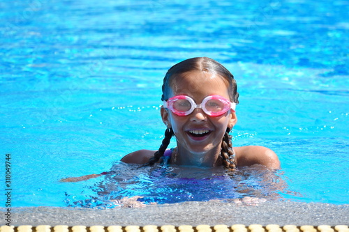 Cute girl enjoys in swimming pool at the hotel. teenager at resort in water. swimming training. Holidays with children at sea.