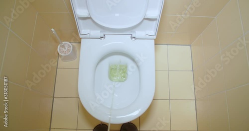 Slow motion shot, peeing, urinating in toilet, first person view. Stream of urine flows into the bowl closeup. photo