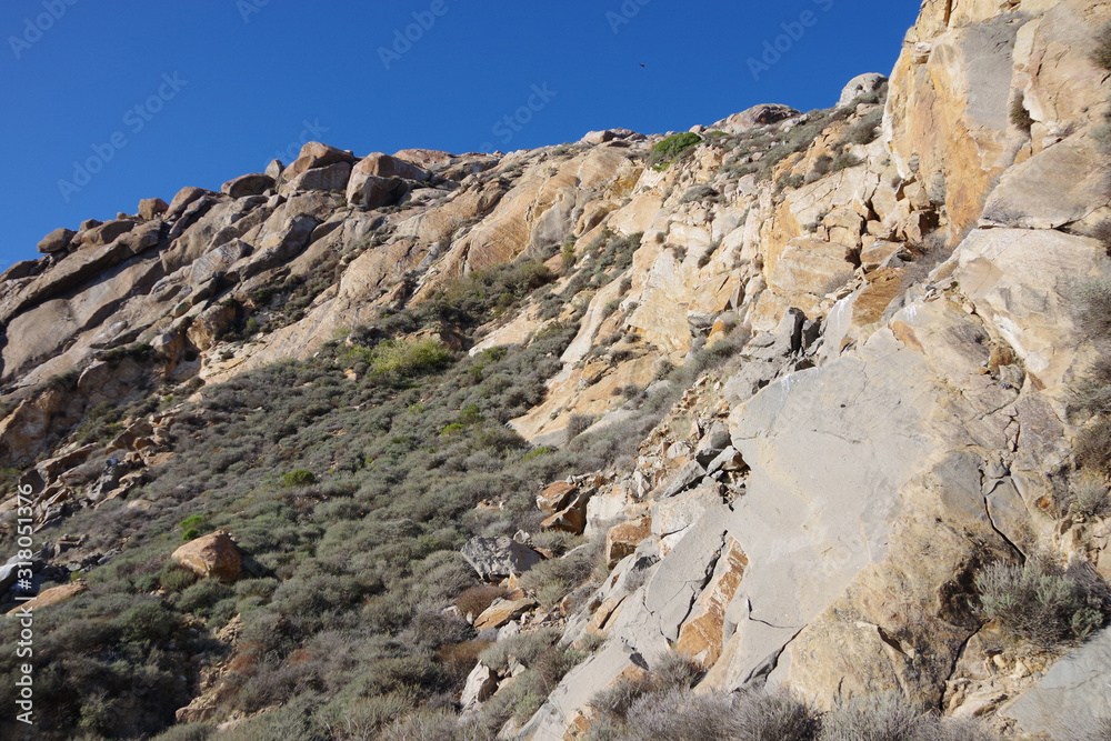 Partial view of the coastal California rock landscape under deep blue sky
