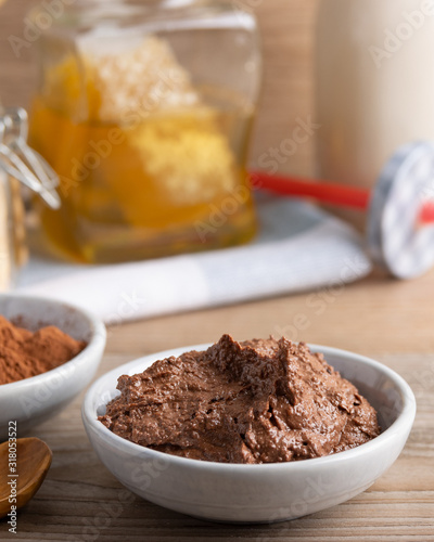 Homemade organic vegan chocolate spread, made of almonds, honey and cacao. With a jar of rice milk