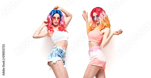 Fashion. Two beautiful hipster woman, stylish clothes, trendy pink hair. Cheerful shapely happy model girl, sisters friends on white. Creative fashionable lady, trendy pink hairstyle concept, banner