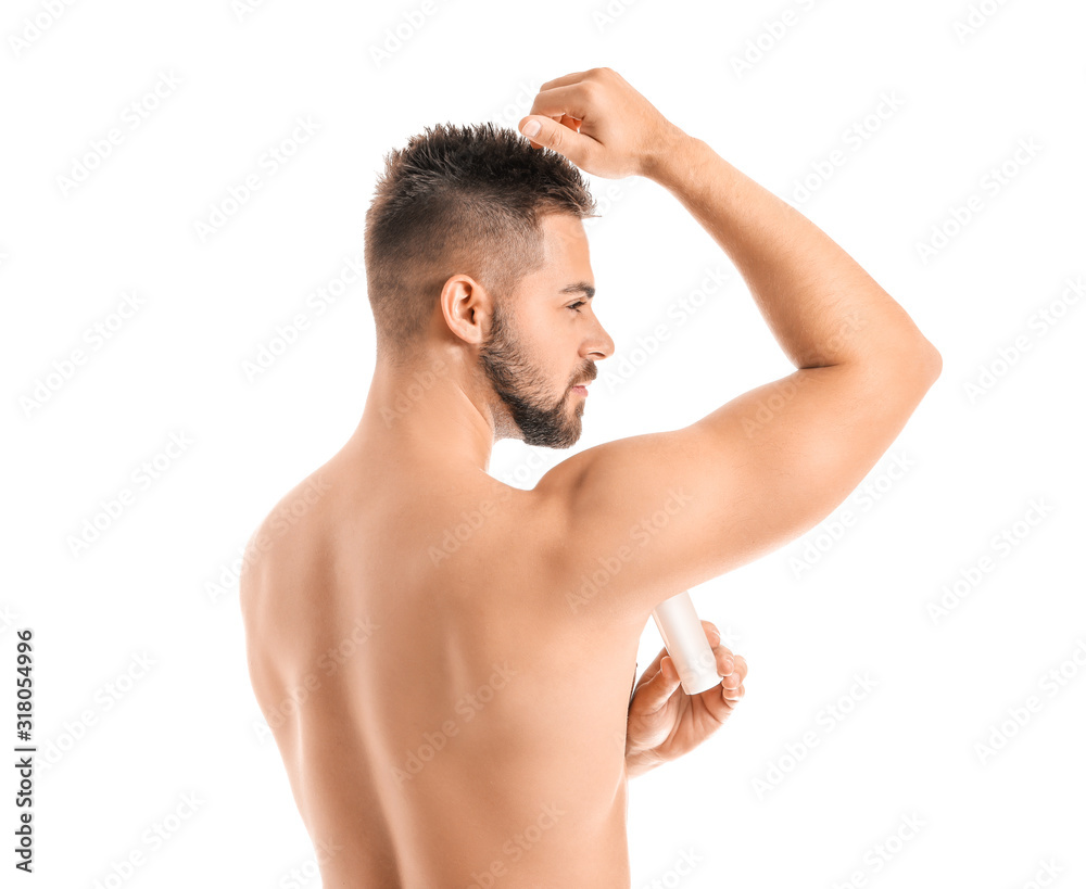 Fototapeta premium Handsome young man using deodorant on white background