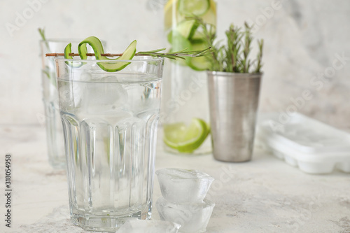 Glass of cold cucumber water on white background