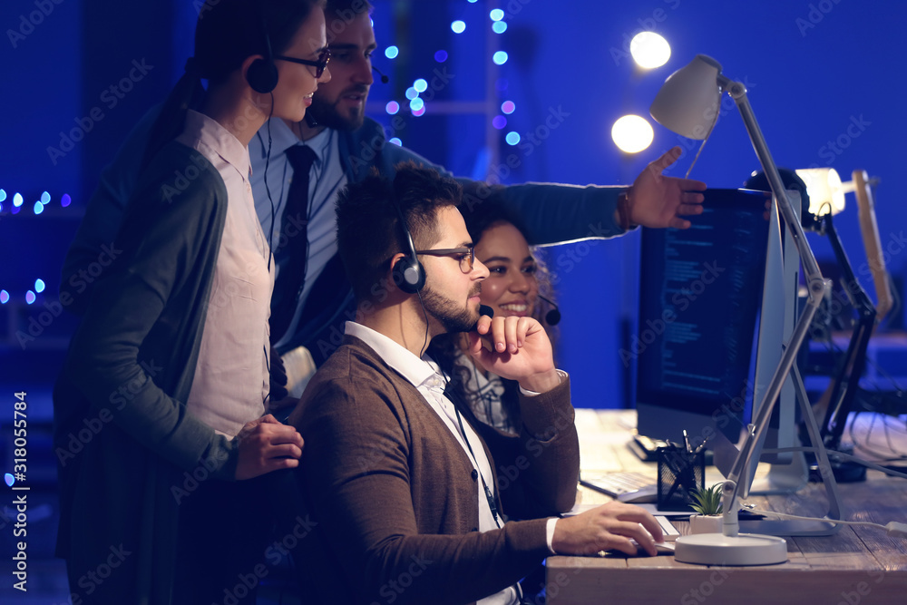 Technical support agents working in office at night Technical support agents working in office at night