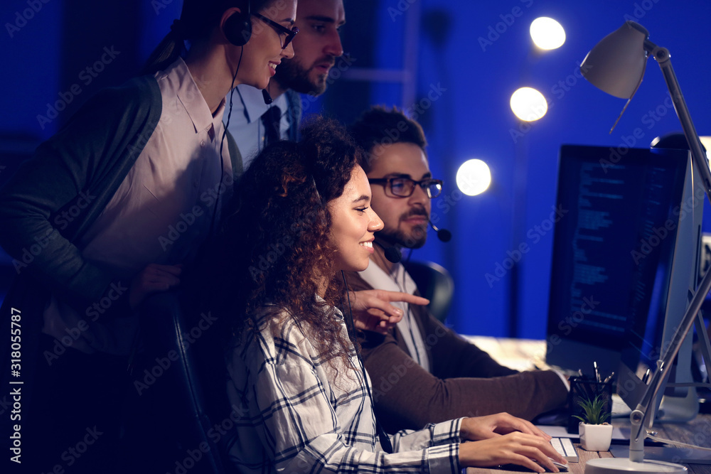 Technical support agents working in office at night Technical support agents working in office at night