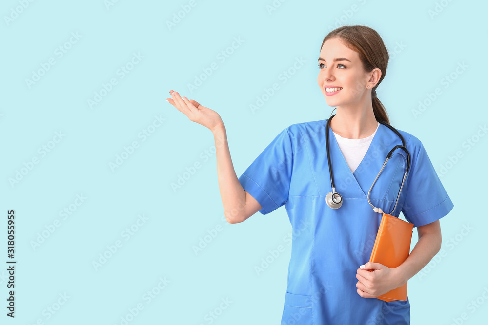 Female medical student showing something on color background Female medical student showing something on color background