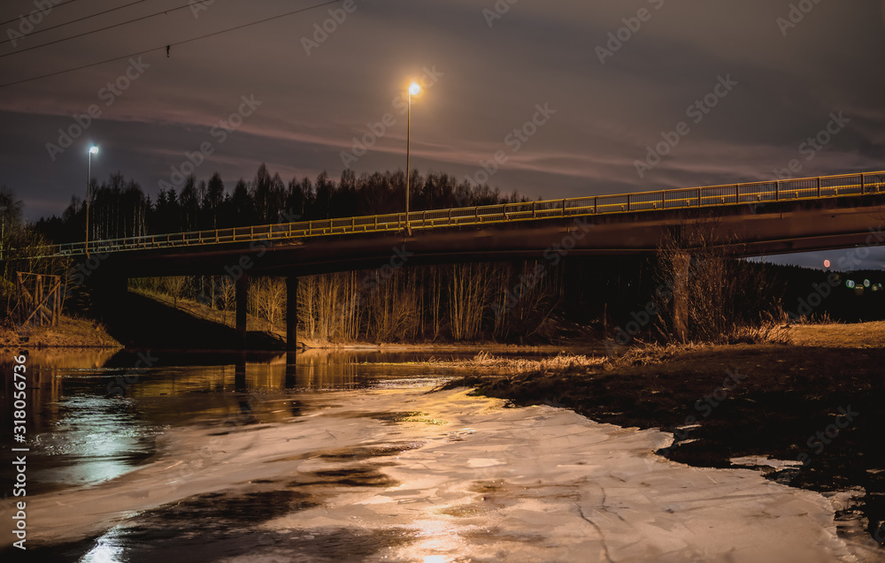 Obraz premium Most na zamarźnietej rzece w nocy