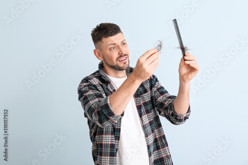 Man with hair loss problem on color background © Pixel-Shot