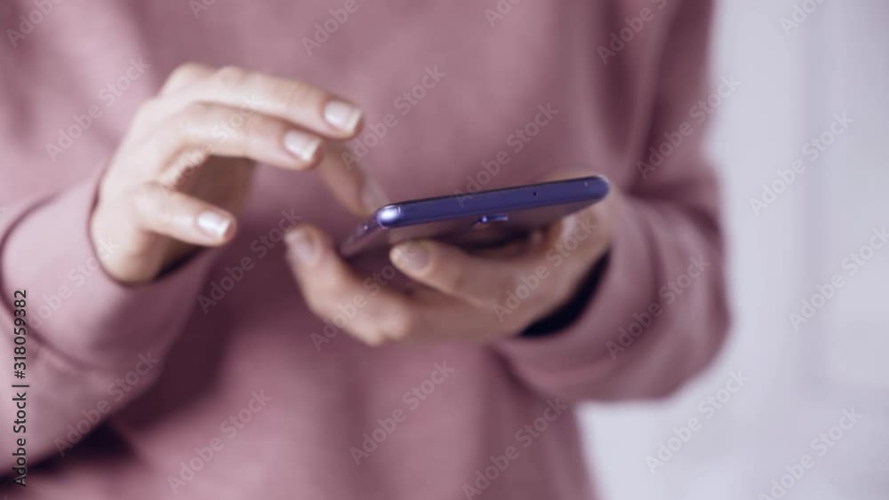Close-up of hands using a mobile phone scrolling on the screen in social networks. Close-up of hands using a mobile phone scrolling on the screen in social networks.