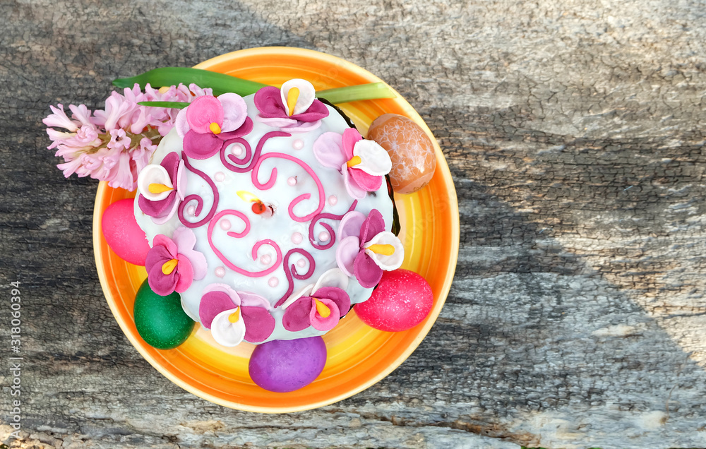 Easter cake with a candle, painted eggs, spring flowers. Easter composition on the old wooden table, top view. Easter cake with a candle, painted eggs, spring flowers. Easter composition on the old wooden table, top view.