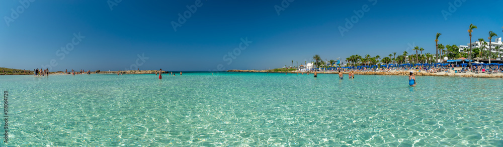 CYPRUS, NISSI BEACH - MAY 12/2018: Tourists relax and swim on one of the most popular beaches on the island.