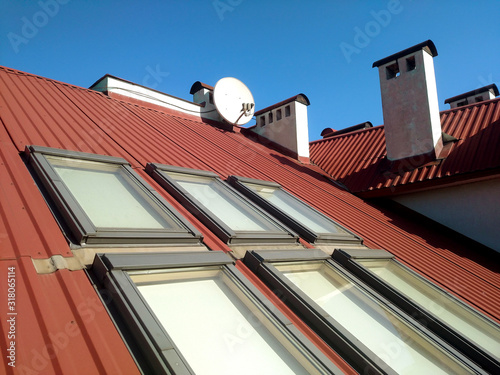Red tiled house roof with attic windows. Roofing construction, window installation, modern architecture concept.