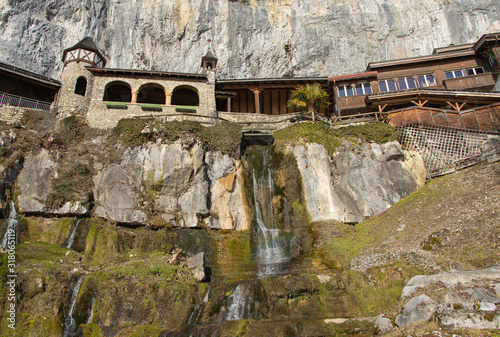 Waterfall below the stonework and wooden arches leading to the St Beatus swiss caves, Beatenberg photo