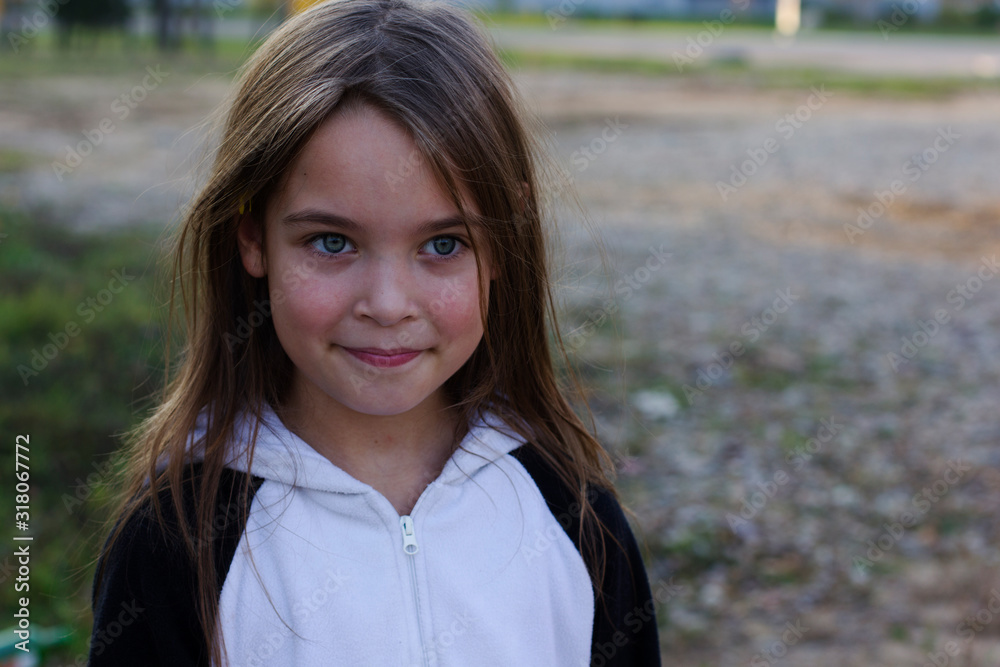 Cute little girl with dark hair is smiling.