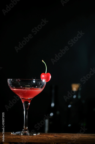 Bartender in a bar mixing alcoholic cocktail. A professional bartender at work in a bar pours a red drink into a glass at a nightclub party.