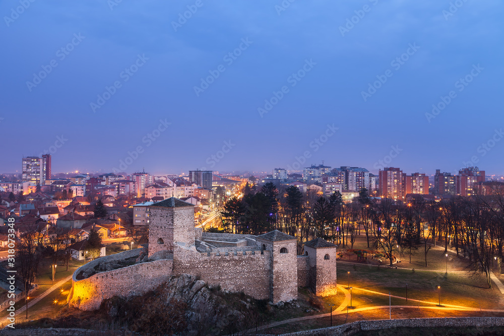 Beautiful lighten ancient foreground fortress and soft cityscape in the back with Christmas and New year decoration during twilight