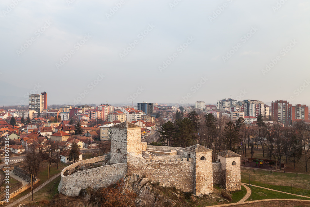 Beautiful panorama of Pirot cityscape, with foreground ancient fortress Momcilov grad and city buildings and houses in the background during cloudy, cold winter day