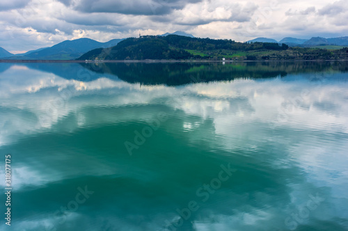 lake liptovska mara in slovakia. wondeful travel destination of high tatras mountain ridge. cloudy weather in springtime. reflection in the water