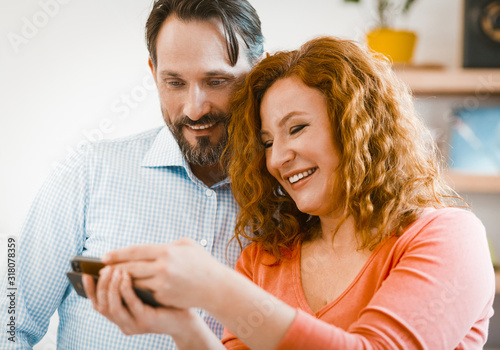 Family couple looking at mobile phone.