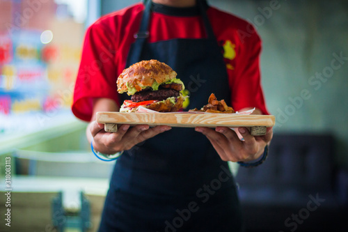 waitress in red uniform serving a burger with french fries