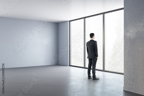 Businessman standing in minimalistic interior