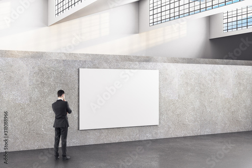 Businessman in minimalistic exhibition hall interior