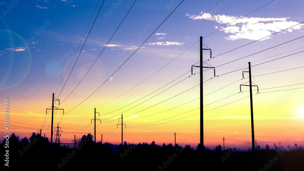 The last rays of the sun. Electricity pylons technology on sunset time background. Electric transmission line, high voltage tower at sunset.