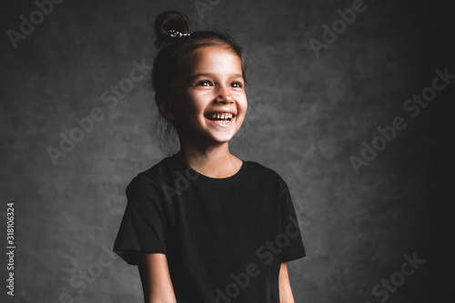 Little girl on a gray background. Portrait in beautiful colors