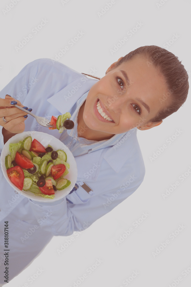 Portrait of a beautiful woman doctor holding a plate with fresh vegetables. Woman doctors. Portrait of a beautiful woman doctor holding a plate with fresh vegetables. Woman doctors.