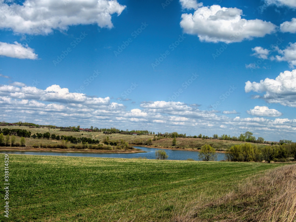 A lake surrounded by fields and forests in summer in Russia A lake surrounded by fields and forests in summer in Russia